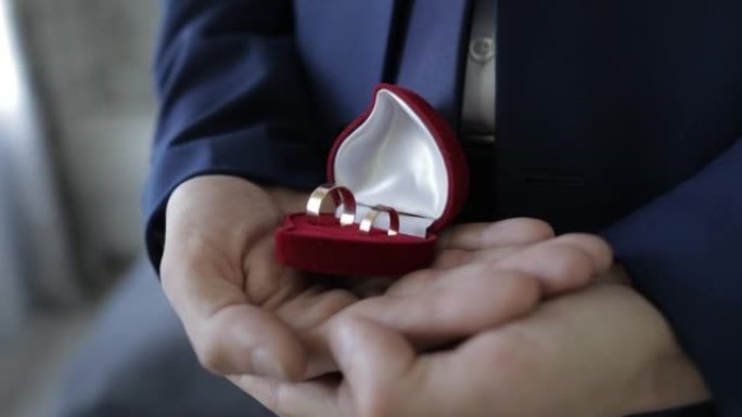 新郎把结婚戒指放在一个漂亮的礼品盒里