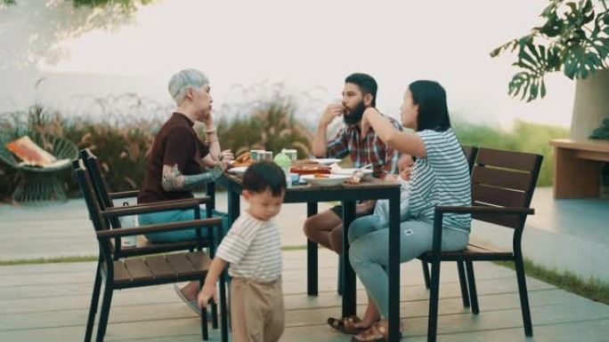 快乐的亚洲多代家庭在后院一起吃饭。