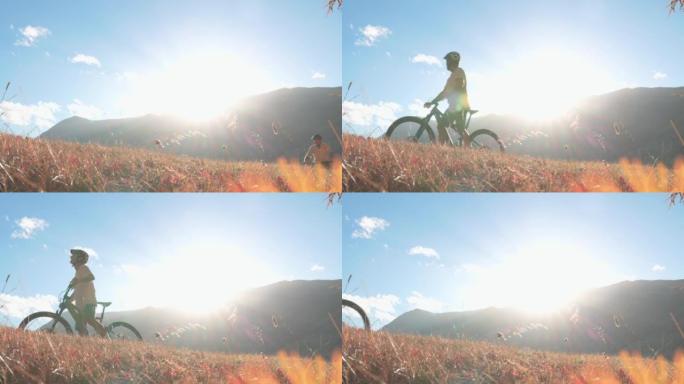 成熟的男性电子自行车手登上山坡，观看日落