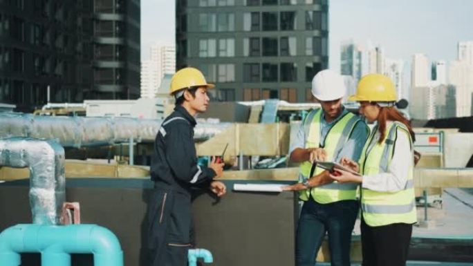 三名不同的专业重工业工程师穿着安全制服和安全帽在平板电脑上工作