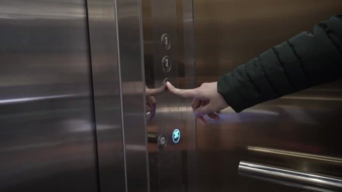 电梯里的女孩按了一个按钮。按下按钮后电梯门关闭。商务中心的现代电梯。那个女人独自一人在电梯里。下到一