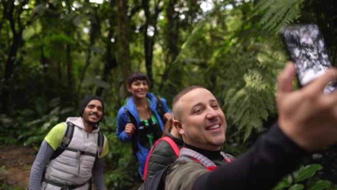 一群人在森林徒步旅行时用智能手机拍摄