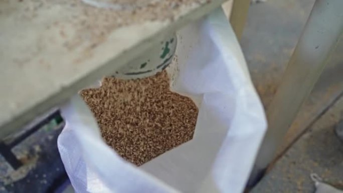 碾米厂。生产健康有机糙米倒入包装袋，慢动作