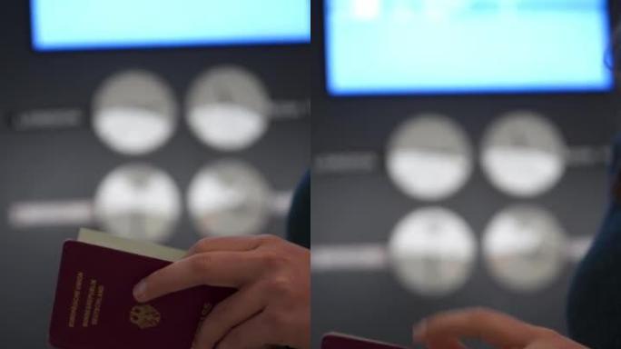 一名妇女在大型世界时钟前的机场里翻阅德国护照的垂直细节镜头