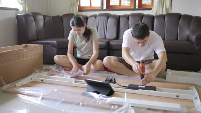 亚洲夫妇在家组装新家具。