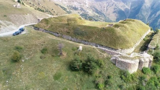 初秋在废墟的堡垒和山脉上高空飞行的鸟瞰图