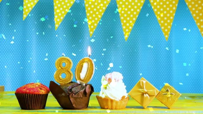 80号生日快乐视频卡。美丽的背景祝贺你的生日，有一个松饼派和一个蓝色和黄色色调的蛋糕和蜡烛。复制空间