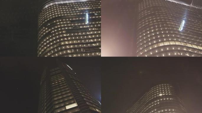 晚上的城市街道。路过照明摩天大楼