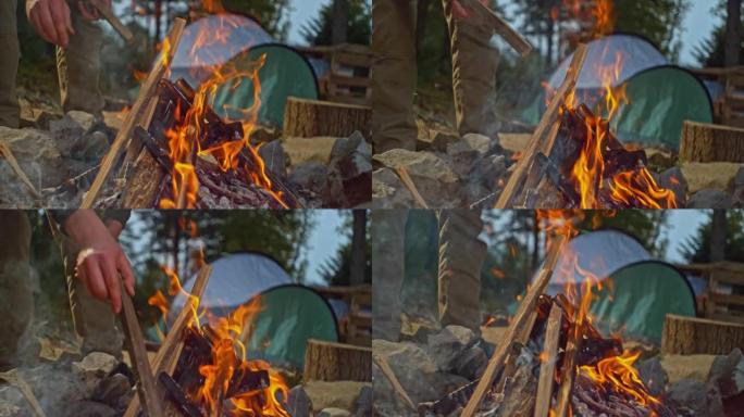 SLO MO Hands在森林的篝火中添加木材
