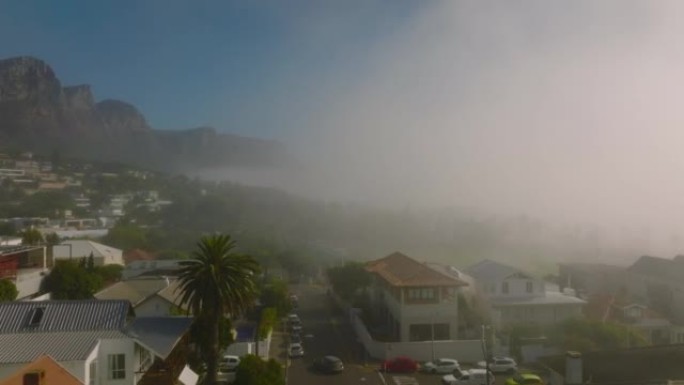在朦胧的日子飞越住宅区。背景中的落基山岭。南非开普敦