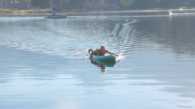 成熟的人在站立桨板 (SUP) 上进入湖中