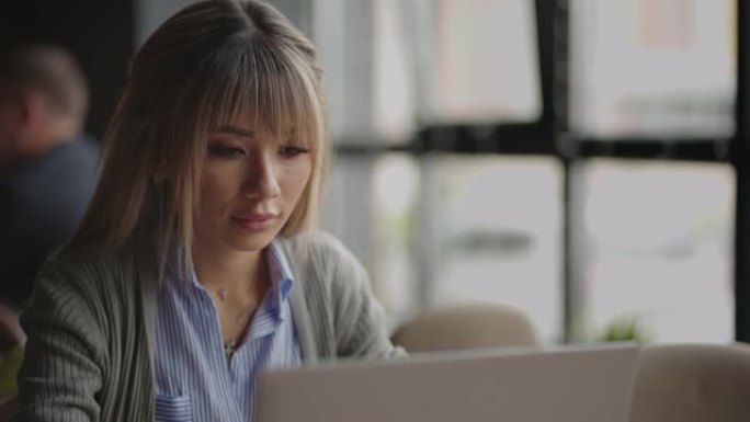 体贴关心的中国，日本，日本，韩国在笔记本电脑上工作的女人看着远处思考解决问题，认真的女人寻找灵感使决