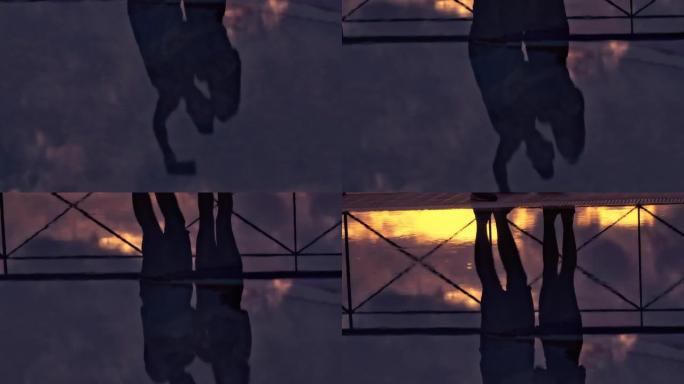 情侣在一个可以看到日落海景的露台上。在泳池反射中自拍