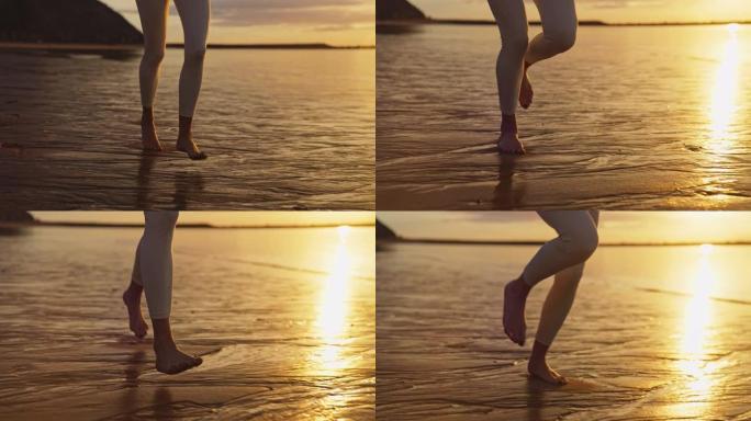 海滨慢跑训练。享受日落和自由的女人。赤脚在湿沙上奔跑