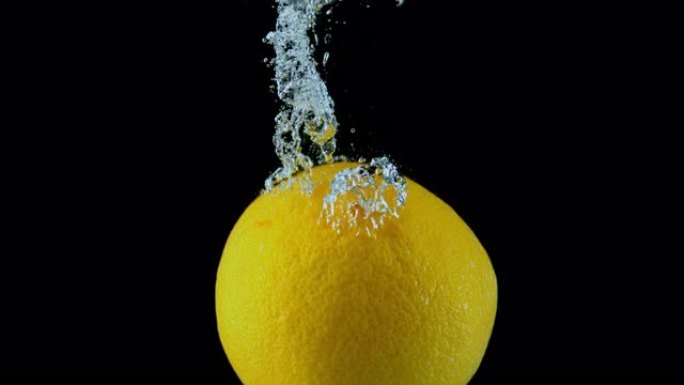 SLO MO LD整个葡萄柚落入水中并产生气泡