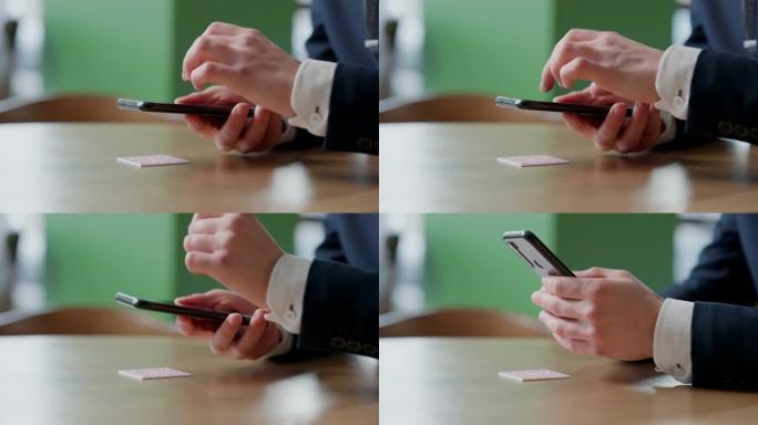 男性手中的智能手机在屏幕上点击特写。无法识别的人在餐厅或咖啡馆的桌子上扫描二维码。客户的在线菜单。便
