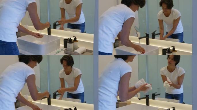 在家中的成年妇女一边照镜子一边洗手