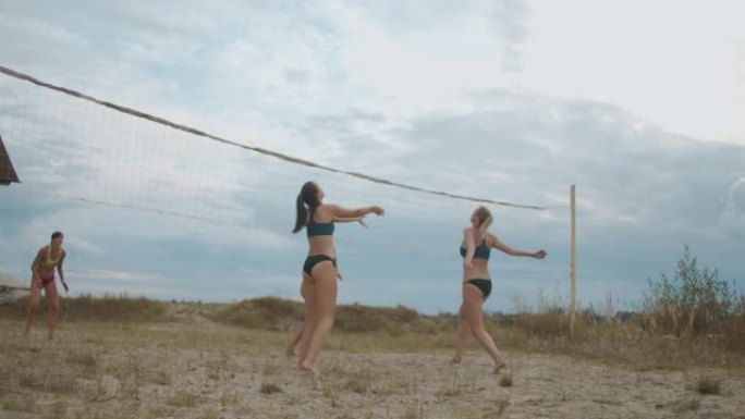 妇女在暑假打沙滩排球，在桑迪球场上进行跳跃和跑步运动员的慢动作射击