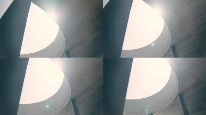 混凝土建筑内的现代圆形窗户。阳光照耀着