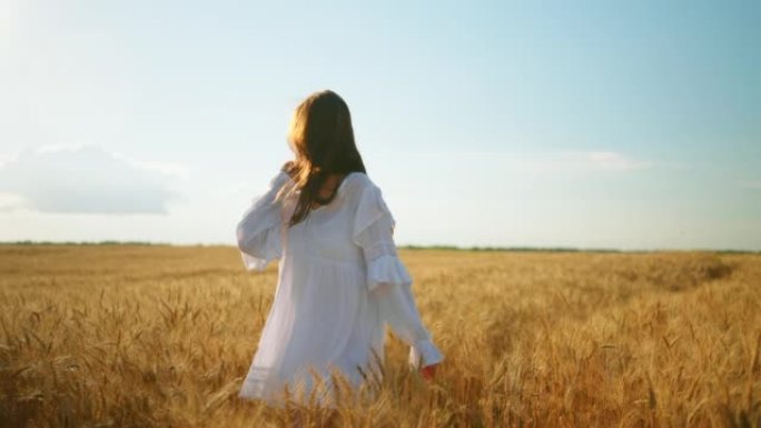 夏天阳光明媚的日子，穿着白色连衣裙的快乐年轻女子带着带面包的线袋在黑麦田里旋转
