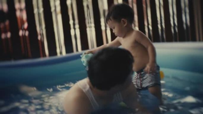 开朗的父亲在教儿子在游泳池里游泳