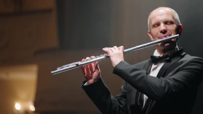 专业长笛演奏家正在老歌剧院演奏旋律，是才华横溢的老年音乐家的肖像