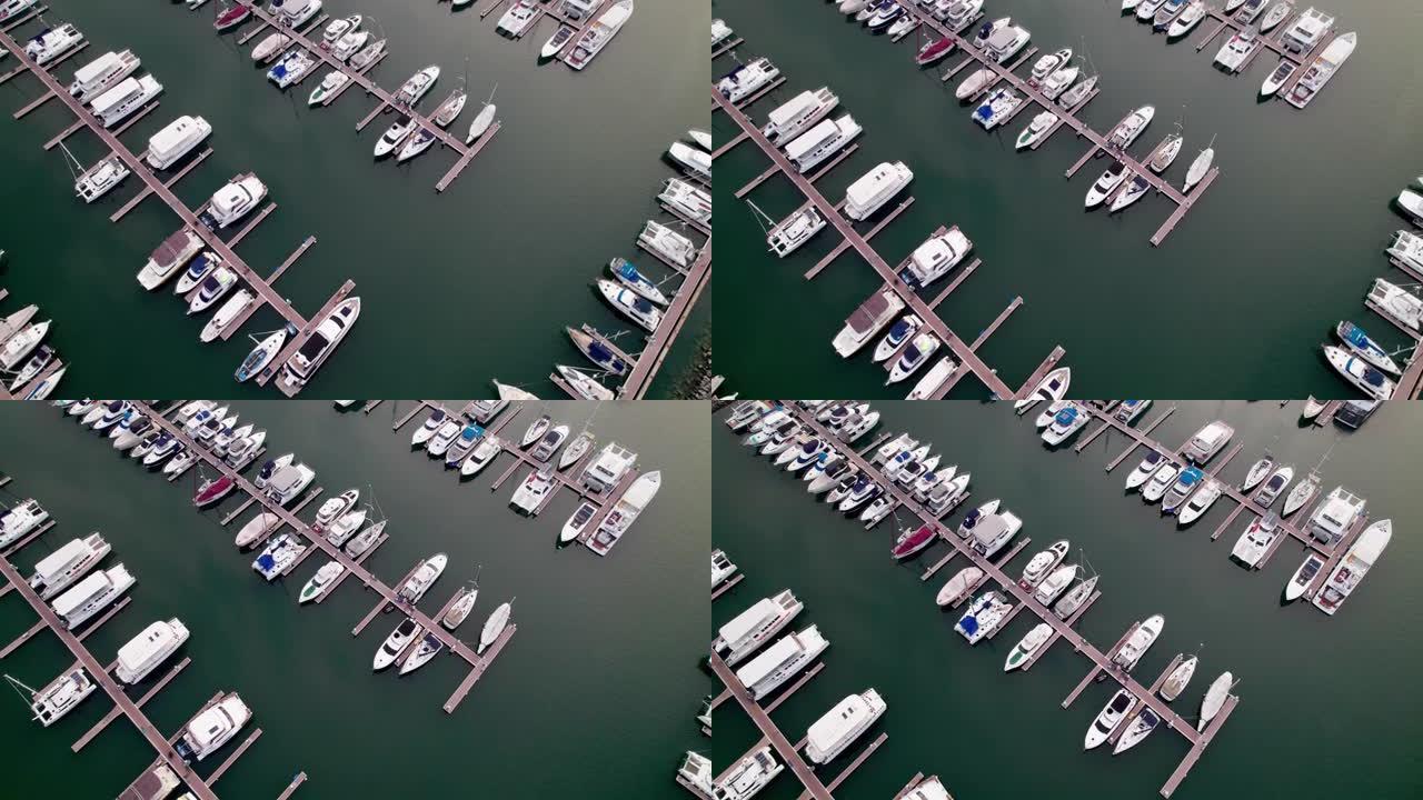 游艇俱乐部的鸟瞰图，以平行模式停泊在一排的停靠帆船的空中广角镜头，属于泰国夏季的一条步行小路。