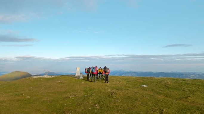 空中徒步旅行者在山顶上举起远足杆