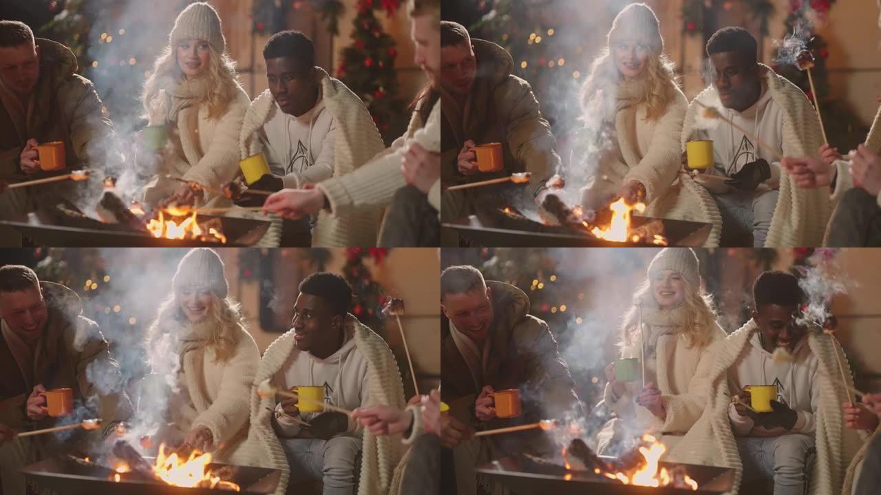 多民族爱心夫妇在朋友圈庆祝圣诞节，在篝火中烤棉花糖
