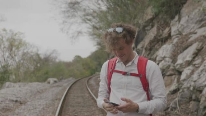 年轻人在远足时在火车轨道上拍照