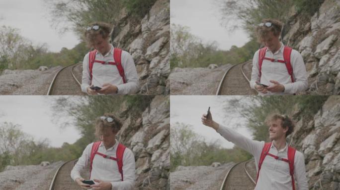 年轻人在远足时在火车轨道上拍照