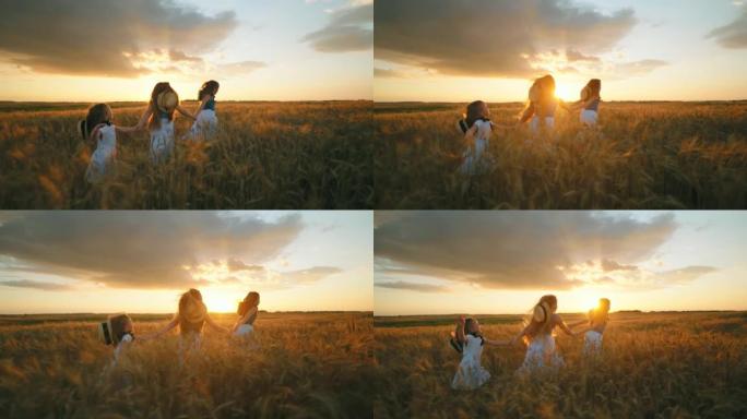 快乐的小女孩朋友或姐妹在日落时牵着手在美丽的金色麦田上奔跑