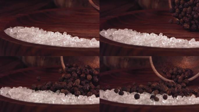 黑胡椒掉在有盐的木桌上。慢动作。特写
