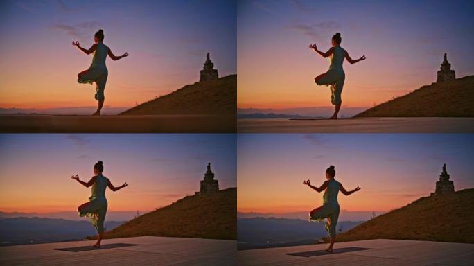 SLO MO女人以瑜伽姿势站在山顶上