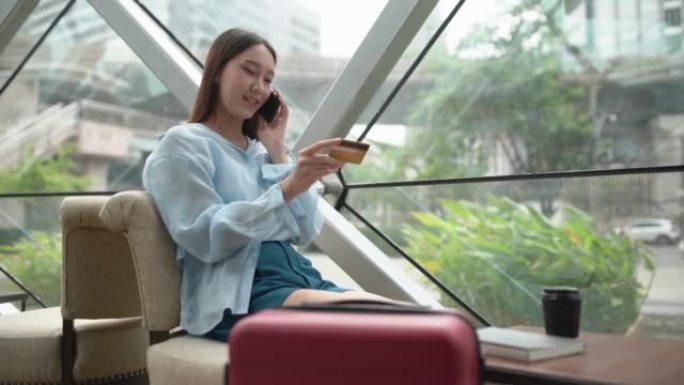 当信用卡呼叫中心批准她的临时信用额度增加时，年轻聪明的亚洲女商人在电话中高兴地微笑