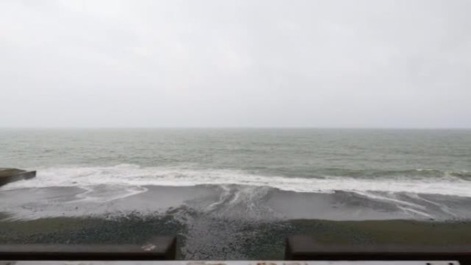 在台风日，沿着海边的道路行驶，看着大海。