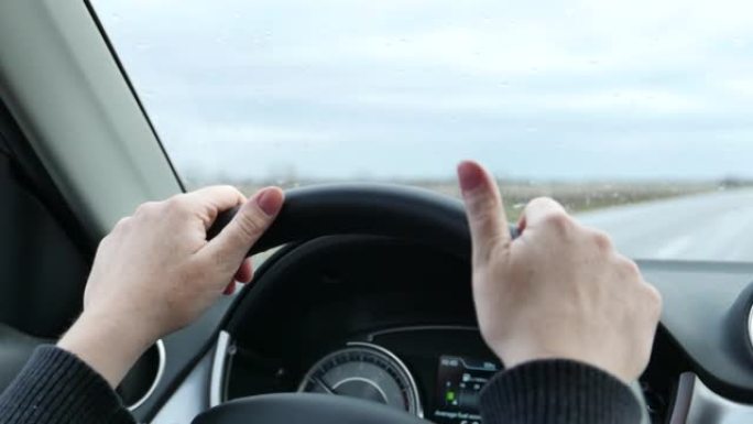 驾驶汽车时女性手在方向盘上的特写