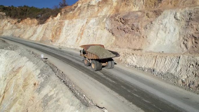 大型采石场自卸车在露天矿上运输矿石，空中慢动作拍摄