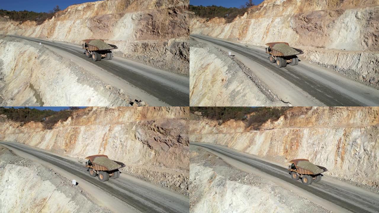 大型采石场自卸车在露天矿上运输矿石，空中慢动作拍摄