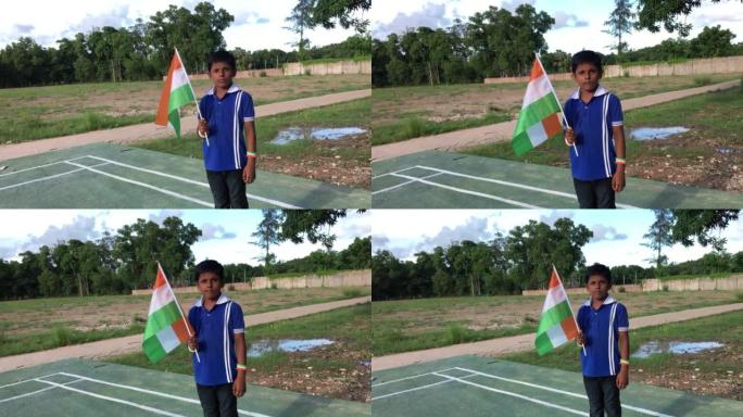 印度小男孩自豪地举着三色旗。印度的国旗，俗称三色旗，是由印度藏红花、印度白和印度绿组成的横矩形三色旗