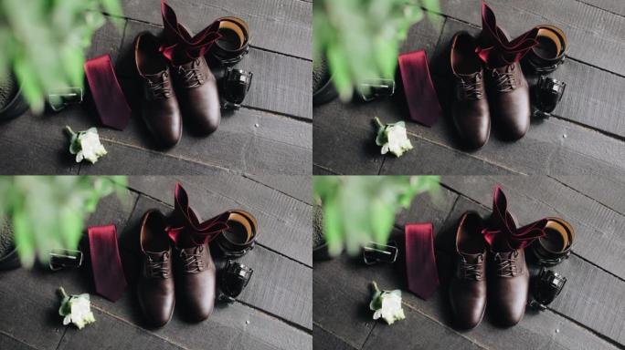男士服装的细节躺在地板上。鞋子、皮带和花露水。顶视图