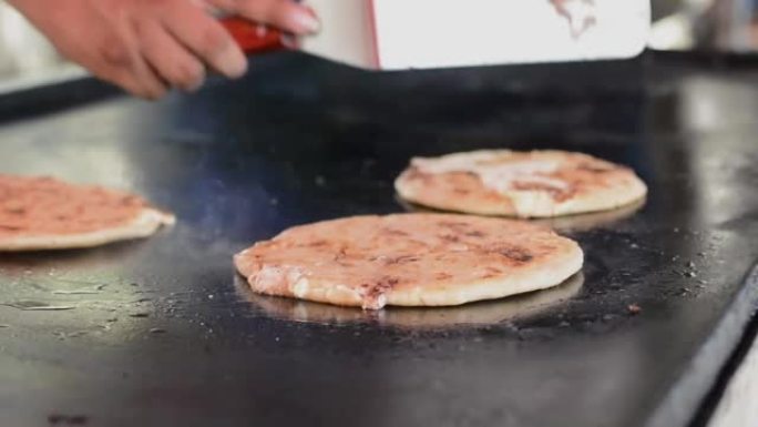 翻转工匠烤pupusas的特写镜头。传统的尼加拉瓜pupusas配融化的烤奶酪。传统烤奶酪pupus