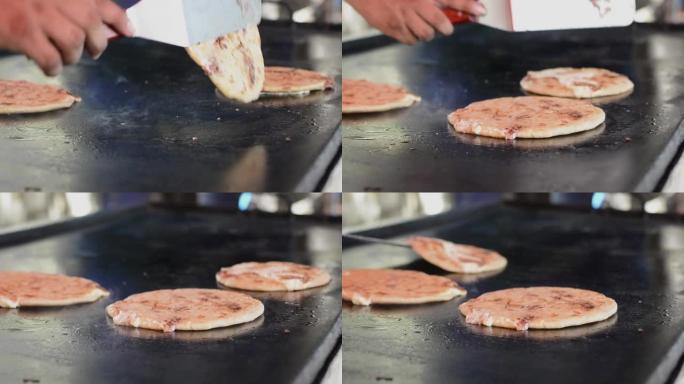 翻转工匠烤pupusas的特写镜头。传统的尼加拉瓜pupusas配融化的烤奶酪。传统烤奶酪pupus