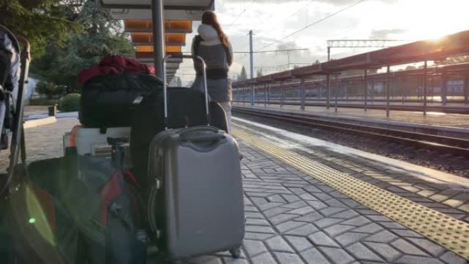 带着小孩乘火车旅行的家庭，带着婴儿和行李的妇女在辛菲罗波尔火车站站台上等待火车的到来。