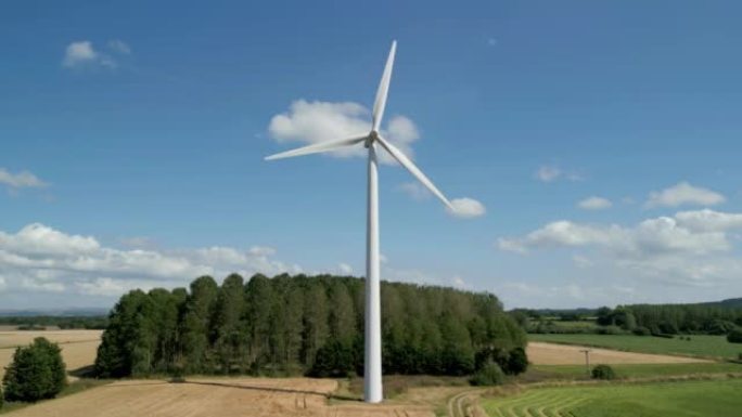 Aerial low level clip of a wind turbine in a small