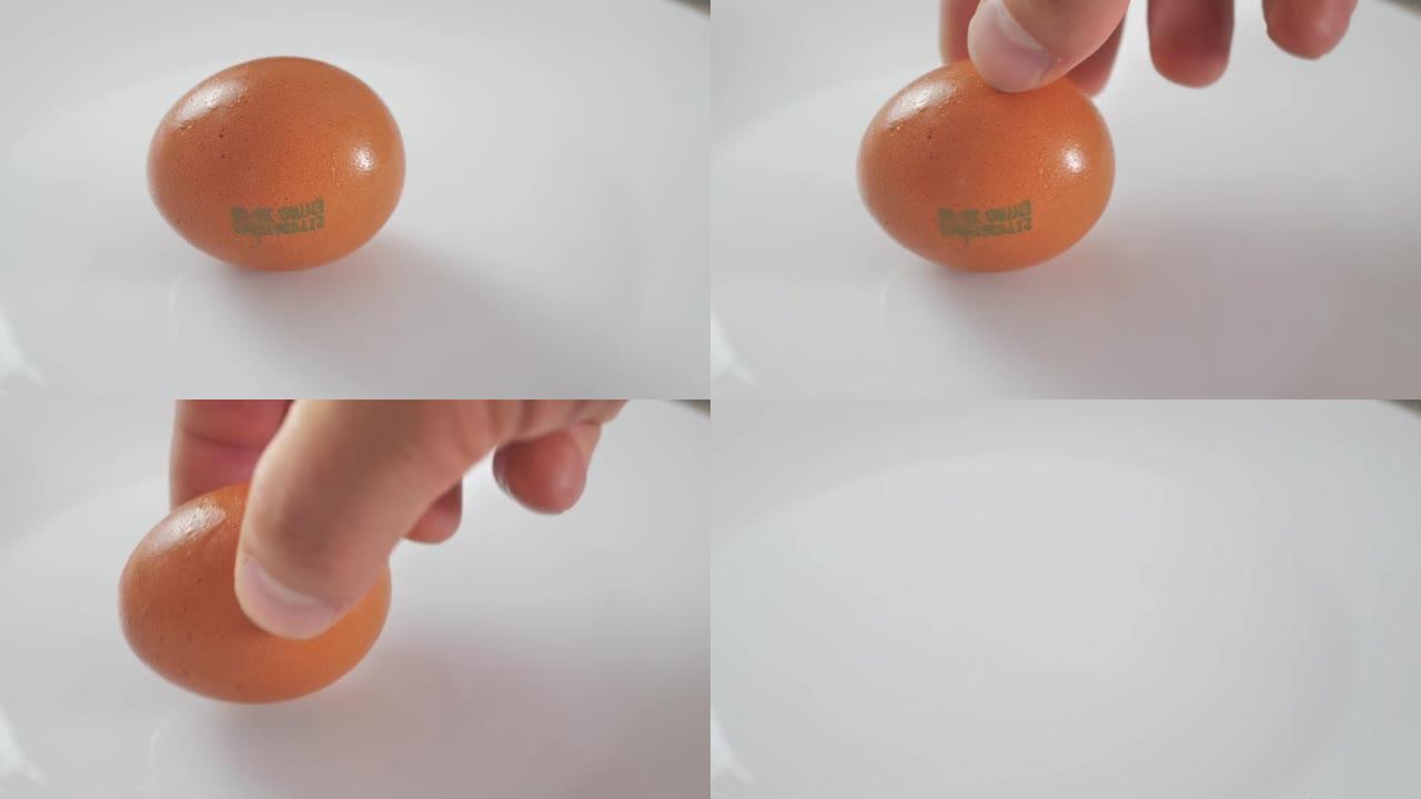 一个人的手从白盘里拿出一个鸡蛋。特写
