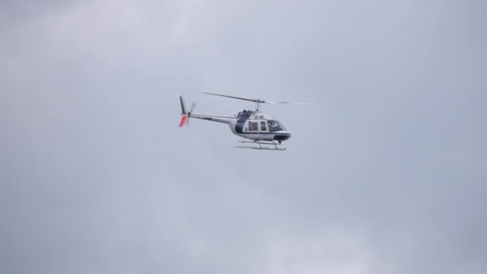 直升机在灰色的天空中飞行，慢动作