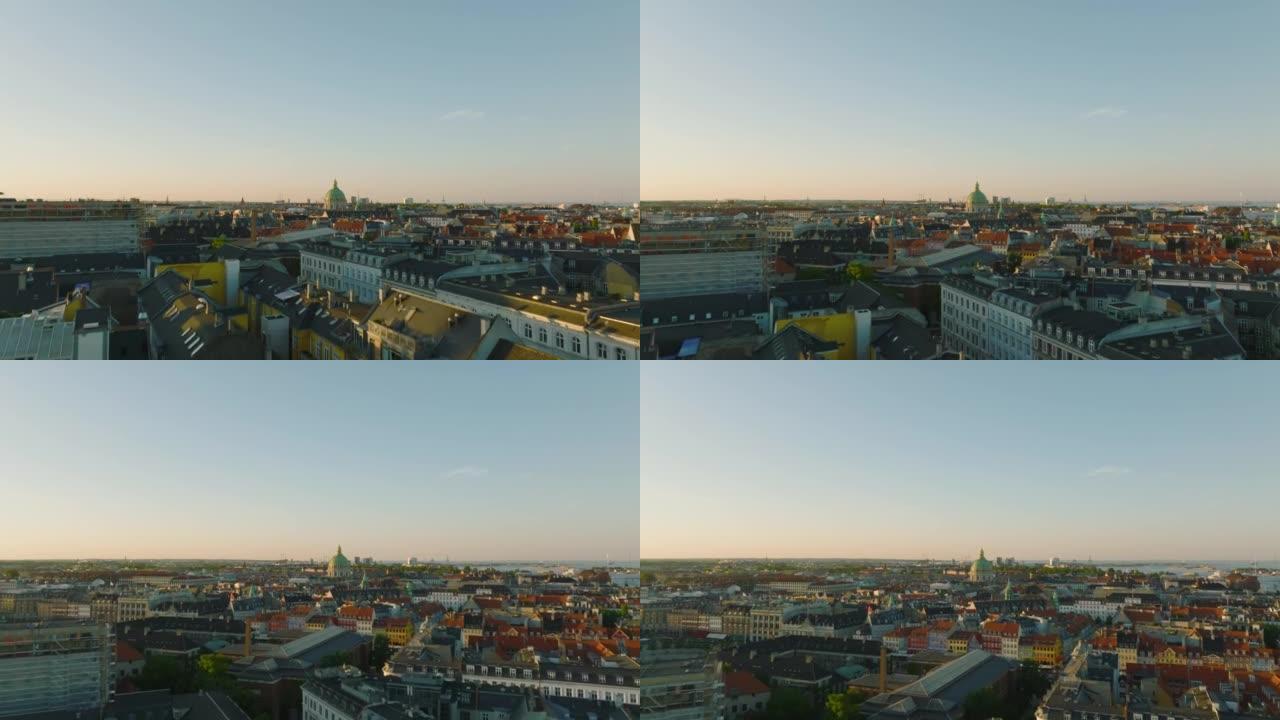 黄金时段城市历史建筑的空中提升镜头。宏伟的弗雷德里克教堂圆顶高耸在周围的开发项目之上。丹麦哥本哈根