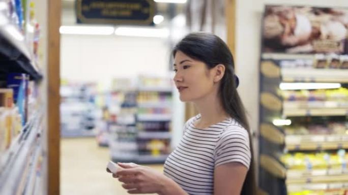 一位亚洲女孩游客从两种产品中选择一种。快乐的商店访客。商店里的产品选择