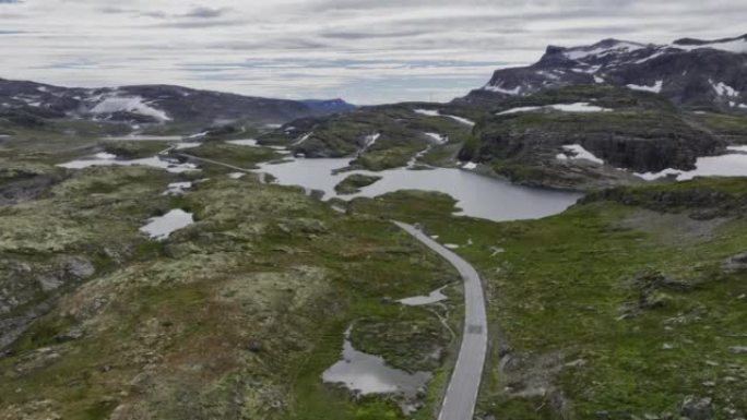 穿过挪威高地的公路上有红船的露营车的风景鸟瞰图